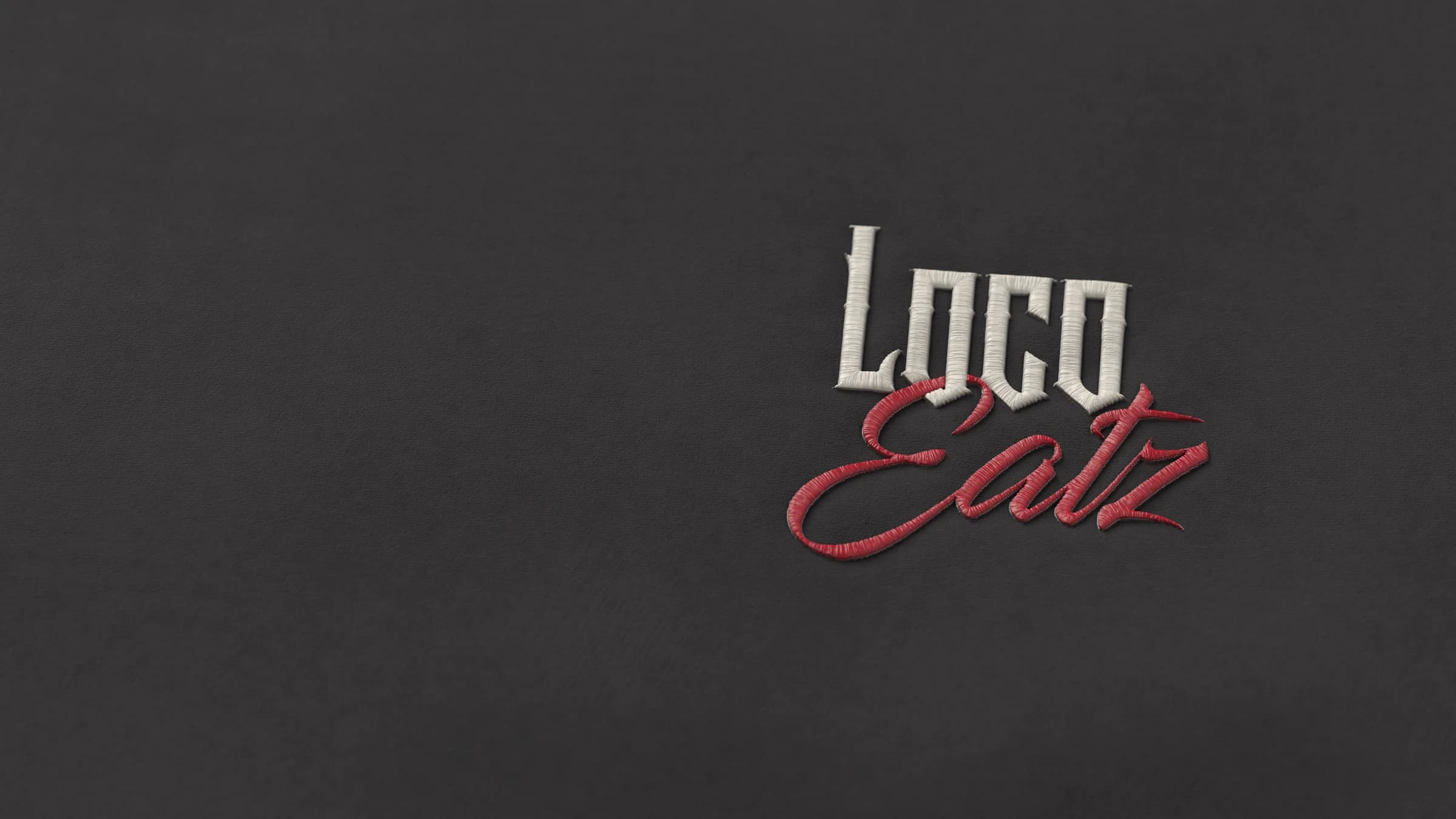 The Loco Eatz wordmark embroidered in raised satin stitch on the Signature Hoodie’s black fleece