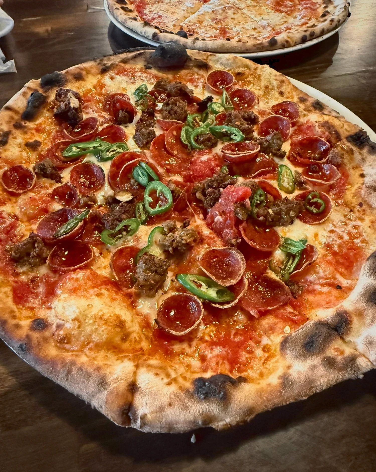 Wood-fired pizza with cupped pepperoni, sausage and sliced jalapeño